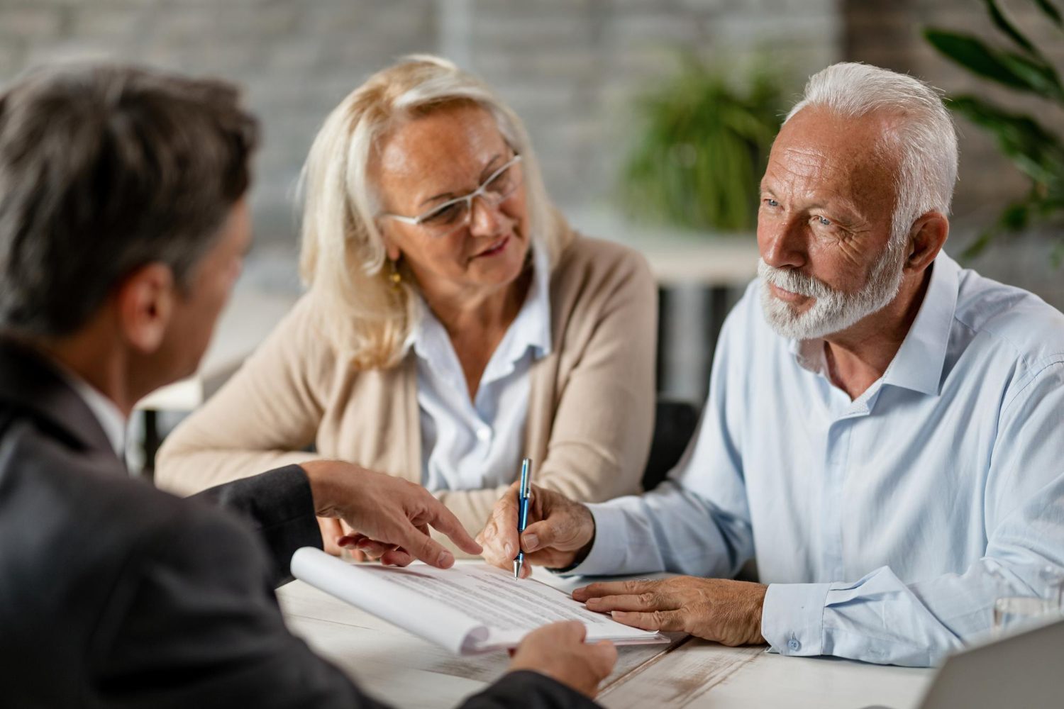 mature couple having a meeting with bank manager and signing lease agreement in the office mature couple having a meeting with bank manager and signing lease agreement in the office